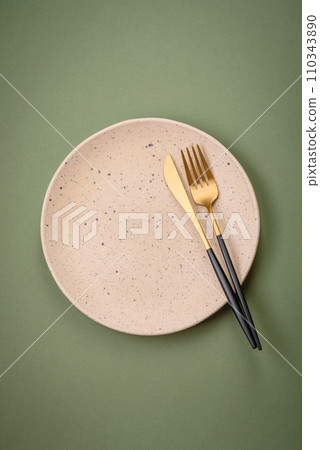 Empty round ceramic plate on a plain background, flatley with copy space 110343890