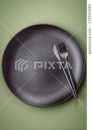Empty round ceramic plate on a plain background, flatley with copy space 110343894