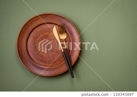Empty round ceramic plate on a plain background, flatley with copy space 110343897
