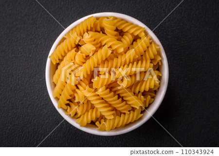 Raw fusilli pasta from whole grain wheat varieties Raw fusilli pasta from whole grain wheat varieties 110343924