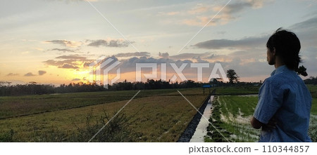 A man looking at the sun in the evening twilight 110344857