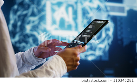 IT developer writing artificial intelligence script code in startup workspace on tablet terminal. Experienced programmer doing maintenance work in high tech facility updating AI systems 110345291