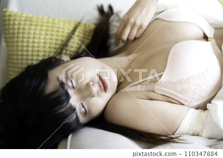 Young woman lying down in lingerie 110347884