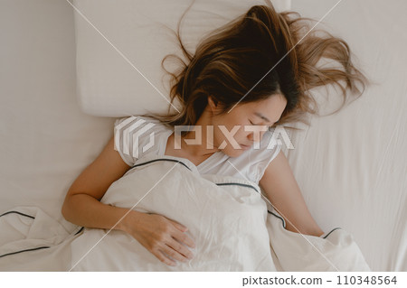 Asian woman sleeping on white bed, fully sleep and rest until morning. 110348564