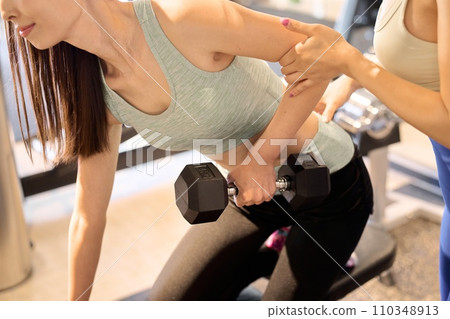 女人用單手啞鈴划船訓練背部和手臂 110348913