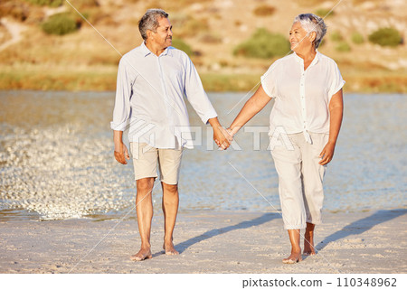 Love, walking and senior couple on a beach lake together for calm, relax and romantic ocean, water or sea date. Elderly happy people, man and woman smile while living pension and retirement lifestyle 110348962