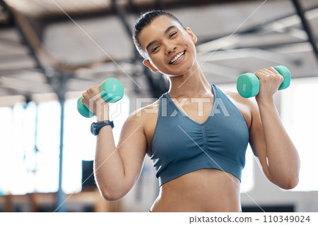 Happy, health and fitness, a woman with dumbbells and a weight training workout. Exercise and beauty, female body builder with a smile in sports gym. Healthy, wellness and lifestyle of a girl athlete Happy, health and fitness, a woman with dumbbells and a weight training workout. Exercise and beauty, female body builder with a smile in sports gym. Healthy, wellness and lifestyle of a girl athlete 110349024