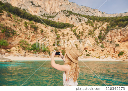Beautiful woman on speed boat driving to paradise beach island taking photo smart phone discover summer adventure vacation Beautiful woman on speed boat driving to paradise beach island taking photo smart phone discover summer adventure vacation 110349273