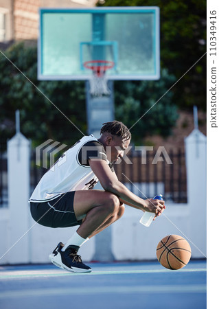 Basketball, sport and fitness with a young man on a court for exercise, training and workout. Health, wellness and fitness with a sporty person resting and drinking water after sports practice Basketball, sport and fitness with a young man on a court for exercise, training and workout. Health, wellness and fitness with a sporty person resting and drinking water after sports practice 110349416