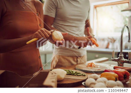 Health, diet and food of a couple cooking a meal together for lunch in the kitchen at home. Man and woman in a relationship working as a team to cook fresh organic vegetables for healthy nutrition. 110349447