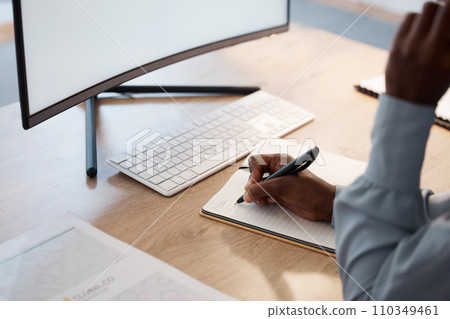 Writing ideas, planning business worker in an office with notebook and blank desktop computer monitor looking online for inspiration. Professional writer or journalist making notes for online website 110349461