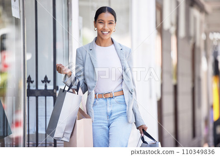 Fashion, retail and shopping with happy black woman excited about a sale, carry bag while walking in a city. Smiling female looking carefree, cheerful fun downtown, positive about discount on clothes 110349836