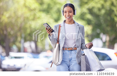 Shopping in city, woman with smartphone and headphones listening to fashion clothes podcast with smile on face for marketing sale tips and style idea. Retail customer with an audio streaming service 110349839