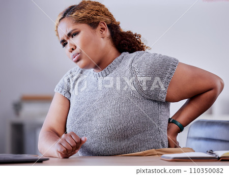 Corporate employee suffering from back pain while working at a desk in an office, uncomfortable and concerned. Young professional experience discomfort from an injury, bad posture or hurt muscle Corporate employee suffering from back pain while working at a desk in an office, uncomfortable and concerned. Young professional experience discomfort from an injury, bad posture or hurt muscle 110350082