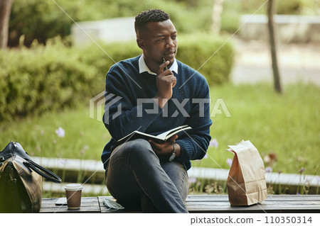 Business man writing in paper book, thinking of creative idea in city and eating lunch in park after work. Employee, worker and corporate person working on schedule and planning strategy with food 110350314