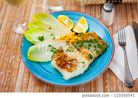 Pink cusk-eel fillet with endive, pickled corn, lemon and greens 110350541