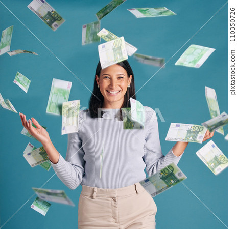 Wealthy, rich and money rain or falling from the sky for financial success and growth. Portrait of a successful, happy and excited female catching cash and enjoying finance investment or lottery win 110350726