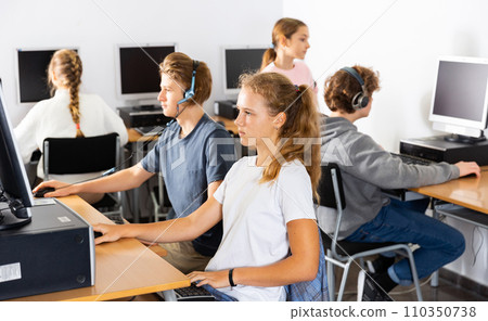 Young boys and girls using computers in classroom 110350738