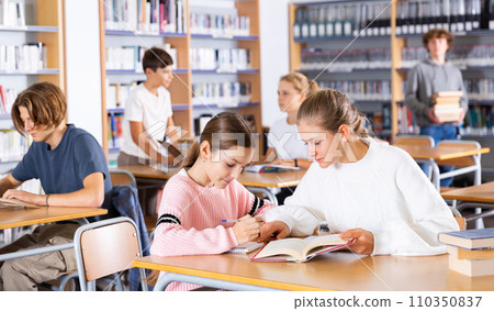 Group of girls and boys preparing for exams in library Group of girls and boys preparing for exams in library 110350837