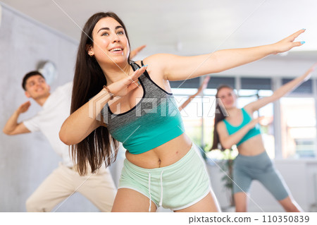 Cheerful hispanic teenage girl showcasing dabbing move during dance class Cheerful hispanic teenage girl showcasing dabbing move during dance class 110350839