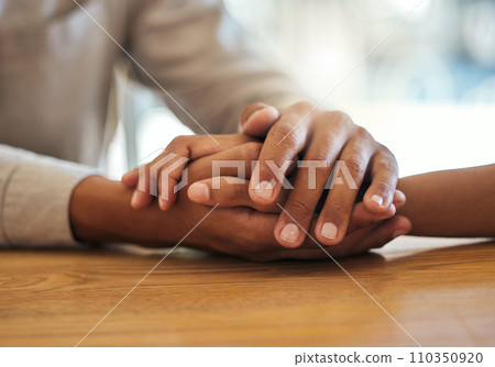 Support, unity and trust by a couple feeling grief due to cancer holding hands together on a table. Closeup of an African American man and woman bonding and connecting due to compassion and love Support, unity and trust by a couple feeling grief due to cancer holding hands together on a table. Closeup of an African American man and woman bonding and connecting due to compassion and love 110350920
