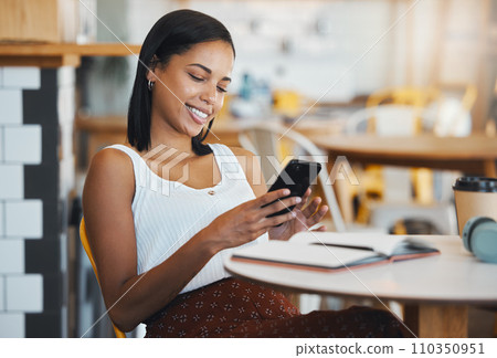 Texting a message or browsing social media on a phone by a young female student sitting in a coffee shop smiling. A relaxed woman relaxing and searching the internet or chatting online at a cafe 110350951