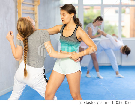 Girl and woman athletes in pair conduct training battle in oriental fighting technique 110351053