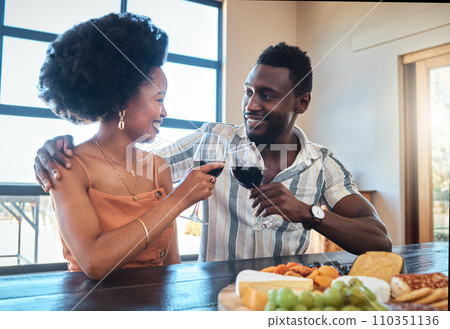 Celebration, love and black couple toasting with wine on a romantic date indoors, bonding and flirting. Lovers happy, in love and carefree, celebrating their anniversary and sharing intimate moment Celebration, love and black couple toasting with wine on a romantic date indoors, bonding and flirting. Lovers happy, in love and carefree, celebrating their anniversary and sharing intimate moment 110351136