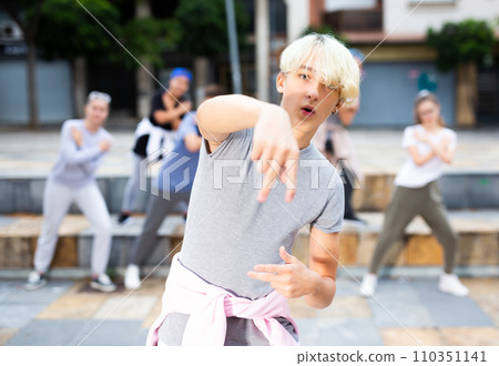 Teen boy dancing modern street dance with teenagers Teen boy dancing modern street dance with teenagers 110351141