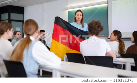Female professor shows students flag of Germany Female professor shows students flag of Germany 110351373