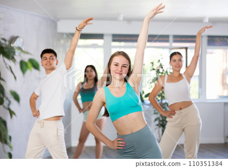 Group of energetic girls and guys learning dance at class 110351384