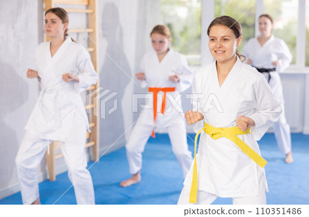 Adolescent karateka practicing punches during kata at group training 110351486
