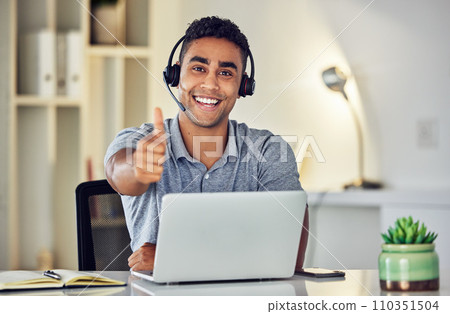 Thumbs up by call center, looking pleased and showing support with hand gesture while working on a laptop in an office alone at work. Portrait of an excited customer service agent expressing thanks Thumbs up by call center, looking pleased and showing support with hand gesture while working on a laptop in an office alone at work. Portrait of an excited customer service agent expressing thanks 110351504