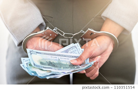 . Handcuffs, dollars and a business woman arrested for theft at work. Money, crime and punishment for fraud with female lawyer in prison. Cash, restraints and a criminal trying to bribe an officer. 110351554