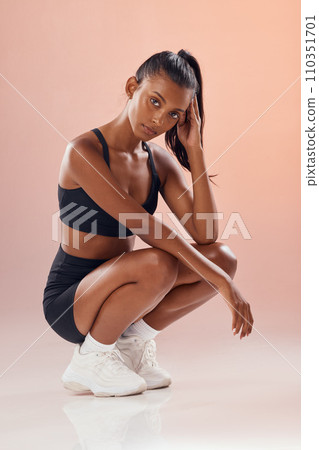 Wellness, fitness and balance of healthy lifestyle and a fit woman sitting against a pink background. Athletic woman with a fit body looking serious, relaxing and satisfied. Lady with a cool attitude 110351701