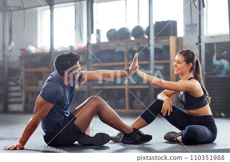 Gym wellness couple high five for success or good exercise and well done gesture for reaching fitness goal. Active trainer and client woman celebrating a great workout, training or exercising session 110351988