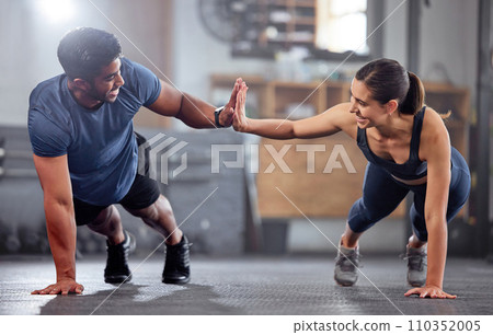 Fitness, motivation and high five while doing push ups and exercising together at the gym. Healthy, fit and athletic couple goals while enjoying a training session with teamwork at a health club 110352005