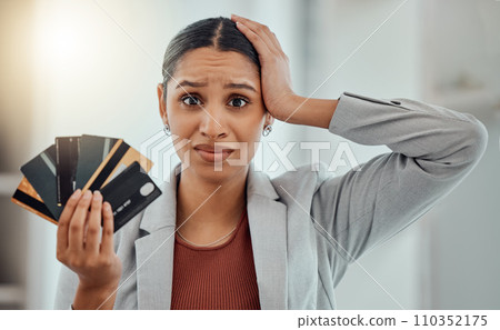 Stressed, worried businesswoman in debt from shopping at work. Female in corporate finance, money issues headache, holds credit and debit cards. Frustration, economic inflation and expenses. 110352175