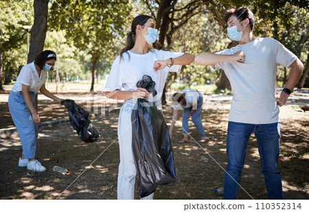 Recycle, volunteer and responsible activist for covid cleaning community park while greeting teamwork with elbow bump. Collecting litter, garbage and trash for sustainable, clean and safe environment 110352314