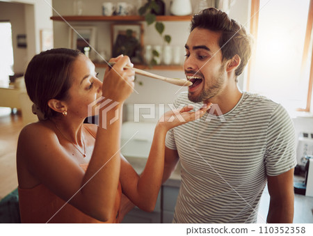 Fun, bonding and a couple cooking in a kitchen at home, enjoying free time on weekend. Young girlfriend and boyfriend learning to cook together while being playful, having fun with their relationship Fun, bonding and a couple cooking in a kitchen at home, enjoying free time on weekend. Young girlfriend and boyfriend learning to cook together while being playful, having fun with their relationship 110352358