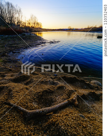 [Kyoto Prefecture/Kizugawa City] Kizugawa River illuminated by the setting sun and floating garbage 110352403