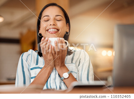 Smiling, cheerful and casual young businesswoman enjoying a cup of coffee in a restaurant or cafe on her lunch break. Portrait of happy customer drinking her morning caffeine or tea beverage 110352405