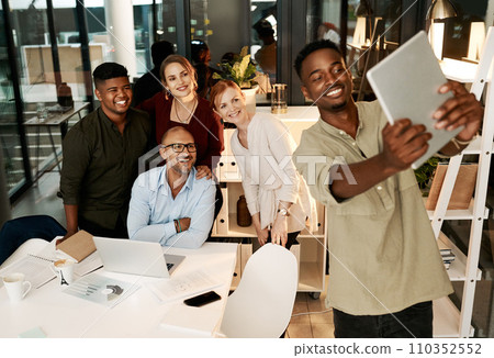 Excited, happy and smiling team of corporate workers taking fun selfie on a tablet in office. Fun, playful and cheerful marketing team posing for social media picture in their new startup agency job Excited, happy and smiling team of corporate workers taking fun selfie on a tablet in office. Fun, playful and cheerful marketing team posing for social media picture in their new startup agency job 110352552