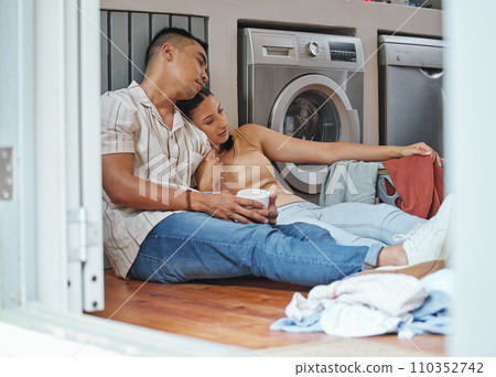 Couple, chores and laundry while doing home cleaning wile feeling tired and relaxing together. Loving boyfriend and girlfriend with a healthy relationship while sitting together on wash day 110352742