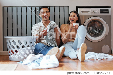 Happy, relaxed and responsible couple doing laundry, household chores or cleaning together on the weekend at home. Young millennial boyfriend and girlfriend enjoying their new modern washing machine 110352744