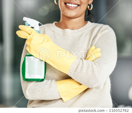 Cleaning, hygiene and chores with a spray bottle in the hands of woman wearing gloves at home. Closeup of housekeeper, cleaner or housewife ready to do housework to keep things neat, tidy and fresh 110352762