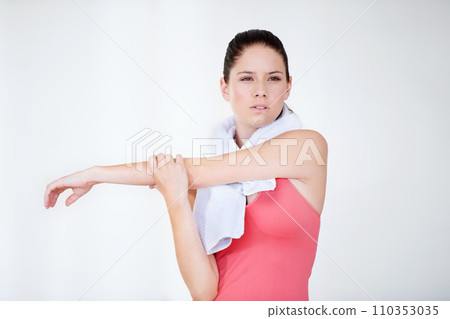 Stretching arm, thinking or woman in gym with towel for fitness, flexibility or wellness on white background. Serious, athlete or healthy sports person ready for workout, training or exercise warm up 110353035