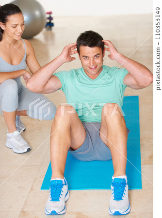 Personal trainer, fitness and portrait of man sit up in exercise and workout for health, wellness and cardio, People, training or coach helping person with core, crunches and pilates routine in gym 110353149