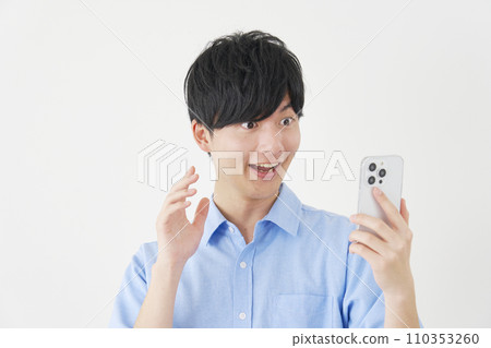Surprised man looking at smartphone, white background Surprised man looking at smartphone, white background 110353260