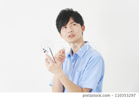 A man holding a smartphone while thinking, white background A man holding a smartphone while thinking, white background 110353297